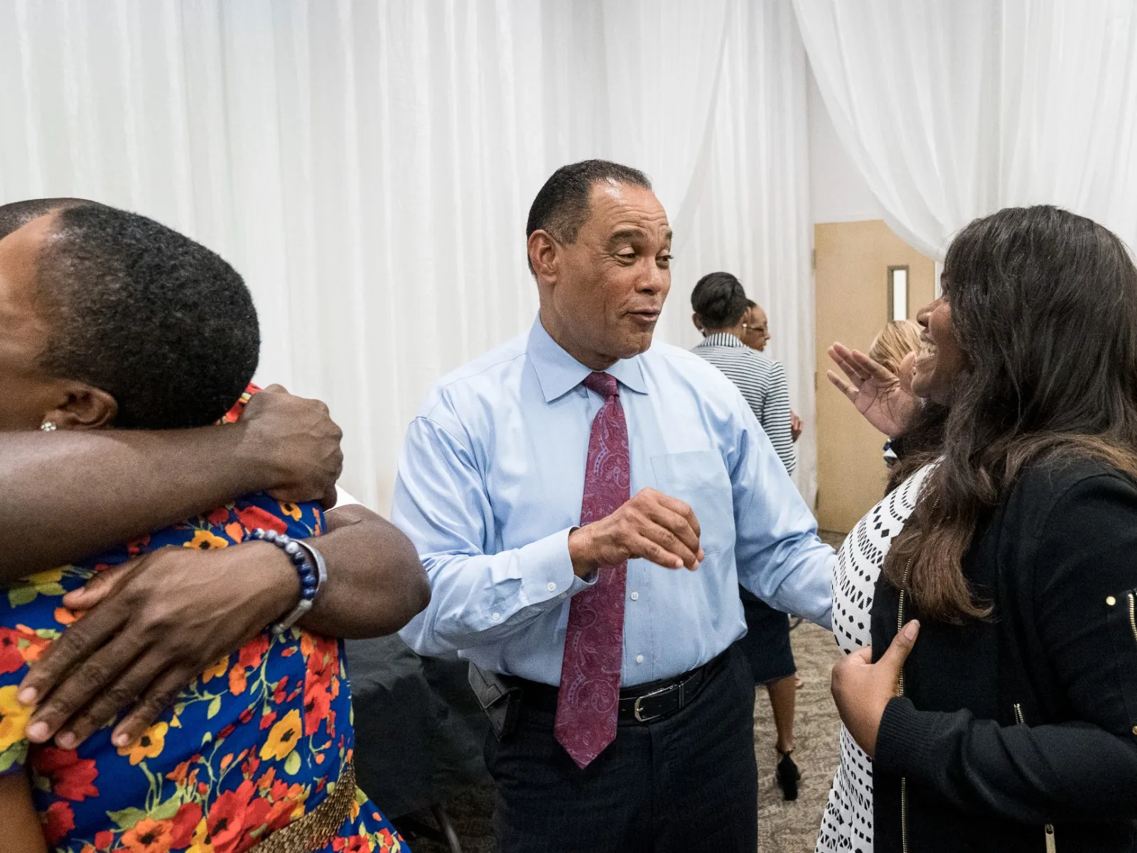 Rudy Moise et al. talking to a group of people