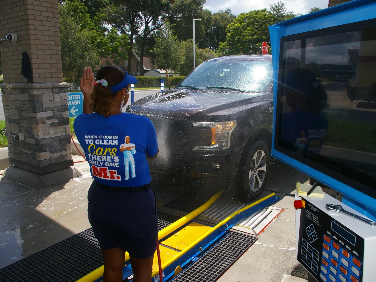 woman showing a guest the touch screen kiosk at a drive-thru