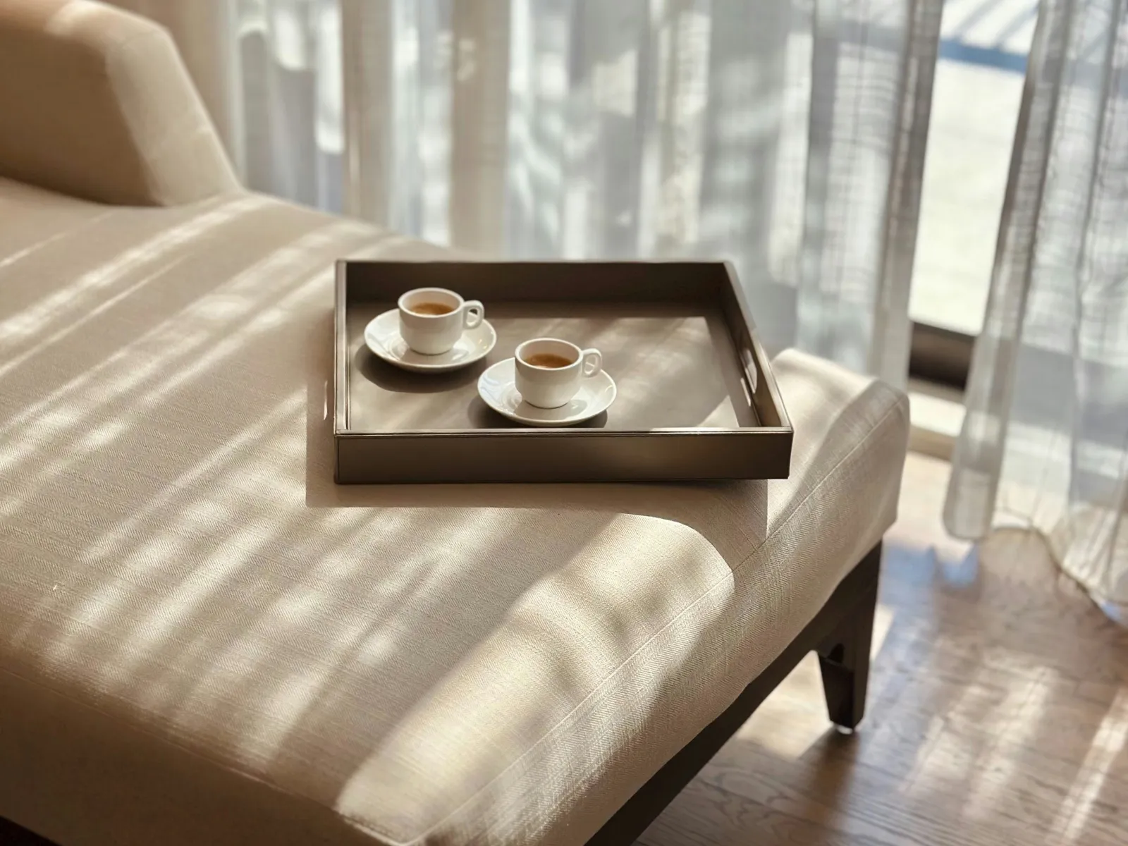 a coffee table with a couple of cups on it by a window