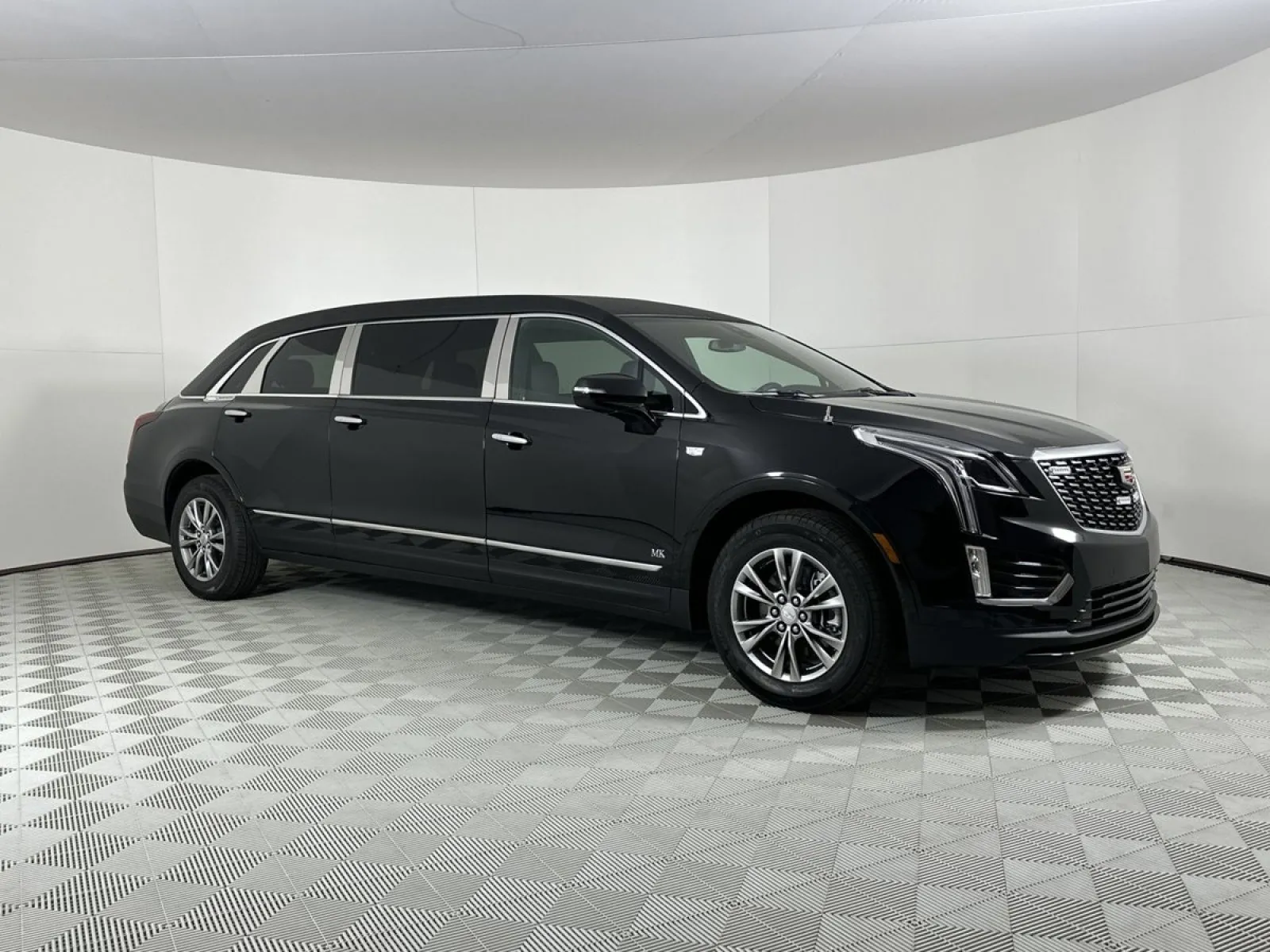 Black luxury Cadillac Escalade SUV parked in a studio with a sleek gray backdrop.