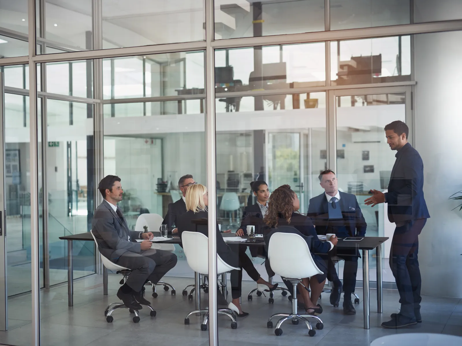 Business professionals in a modern office meeting room during a presentation or discussion.