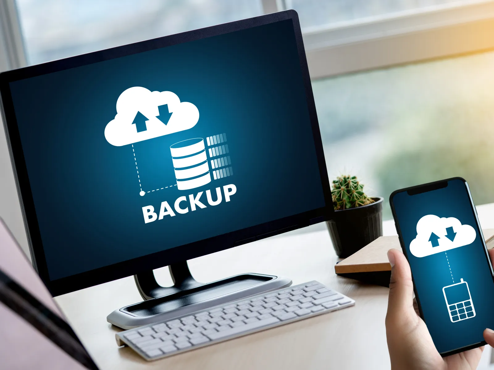 Computer and smartphone screens showing cloud backup icons with data storage and syncing symbols.
