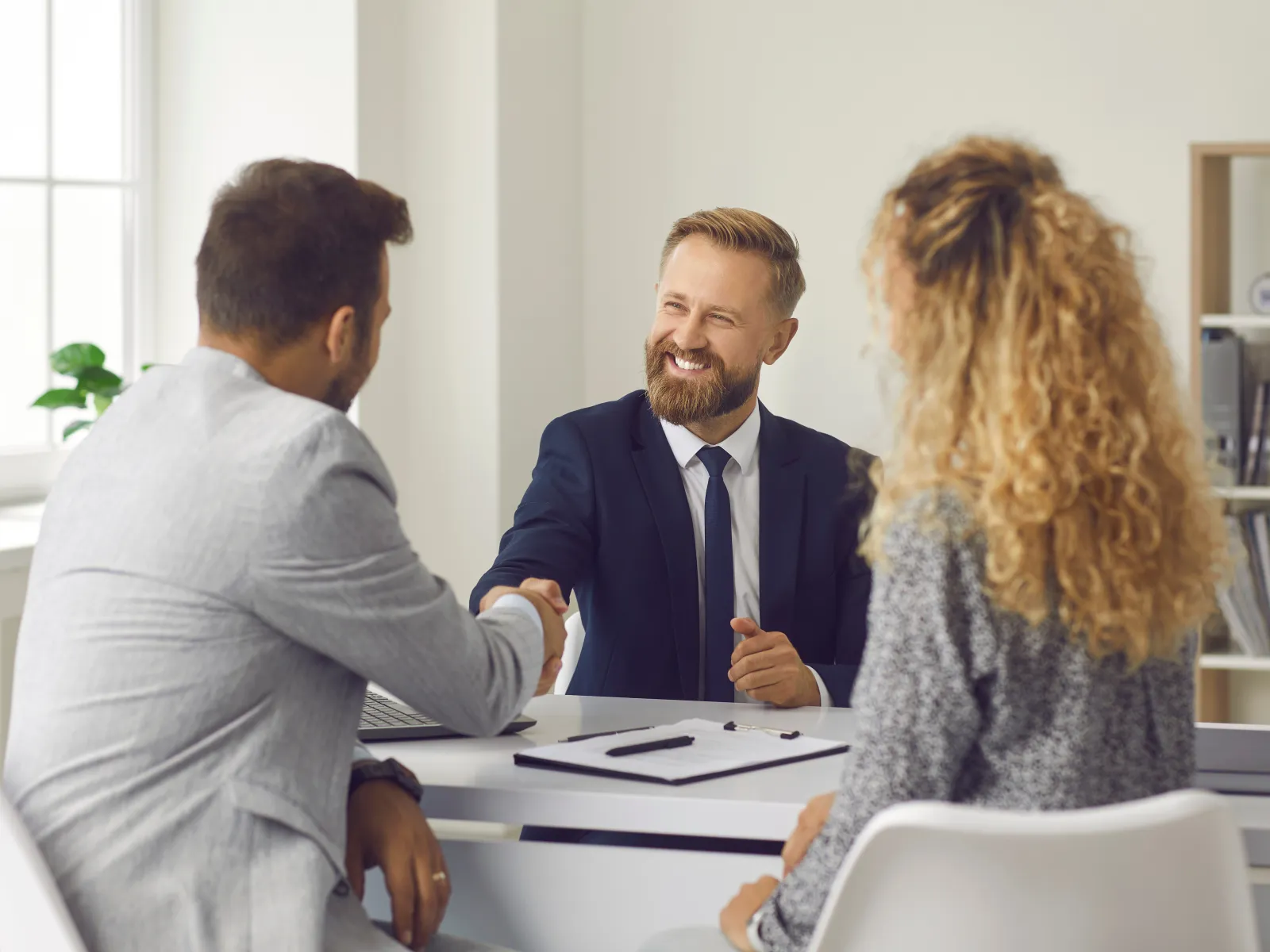 Business team analyzing financial charts and summary report during meeting with laptops and calculator.
