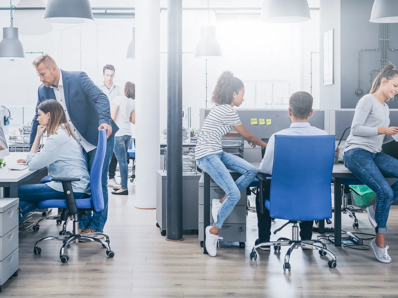 Business team in formal attire collaborating at a modern office table with laptops and documents