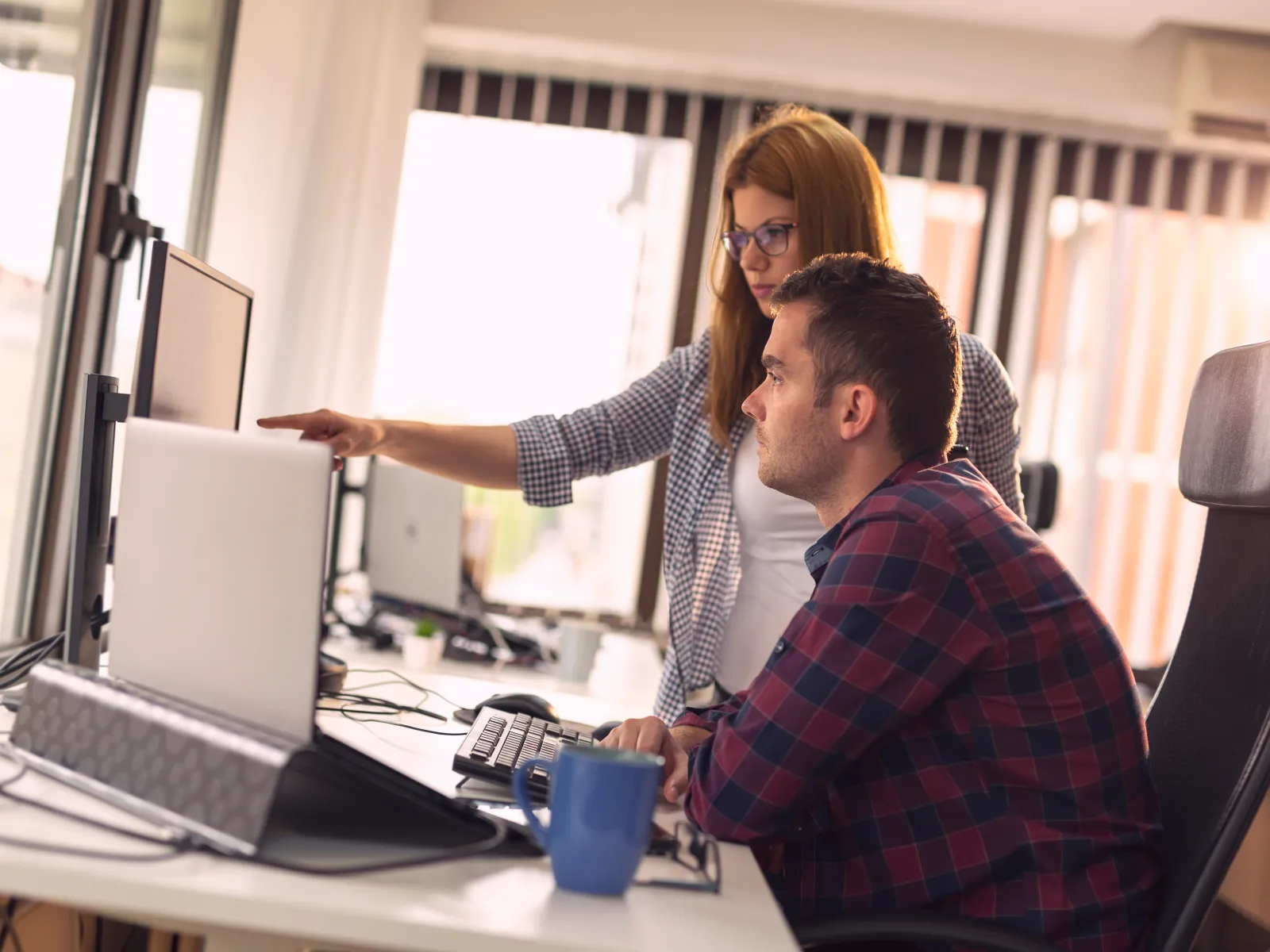 a man and a woman looking at a computer screen