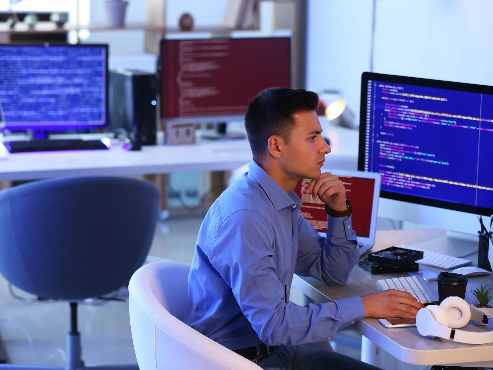 a man sitting at a desk with a microphone and a computer