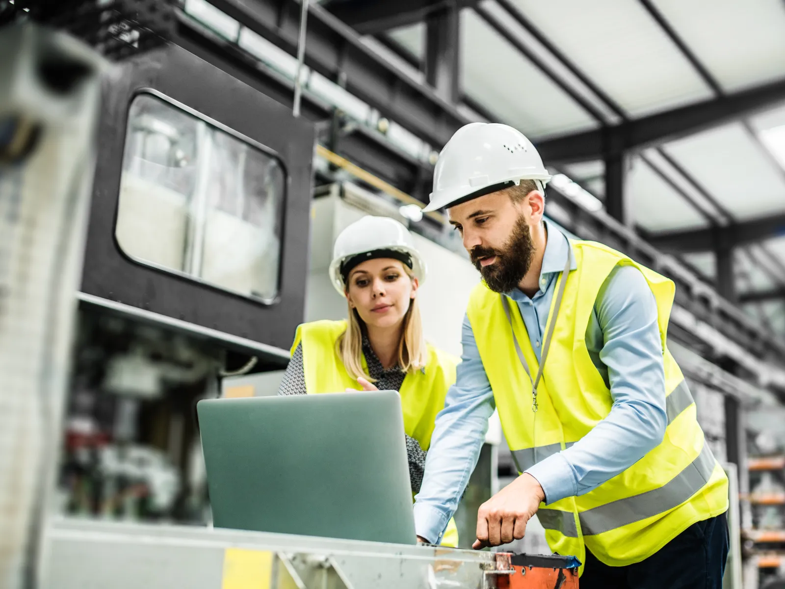 a man and a woman in hardhats in a factory