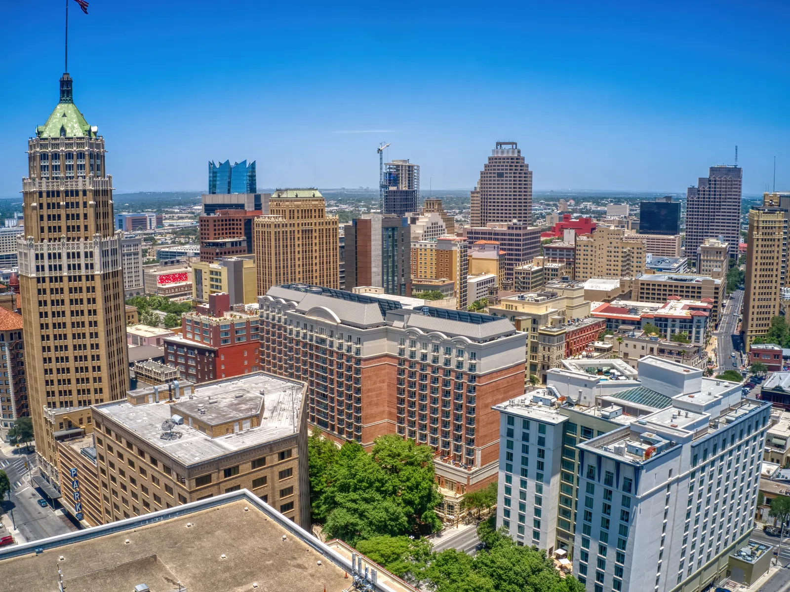 A vibrant city skyline with modern and historic buildings under a clear blue sky during daytime.