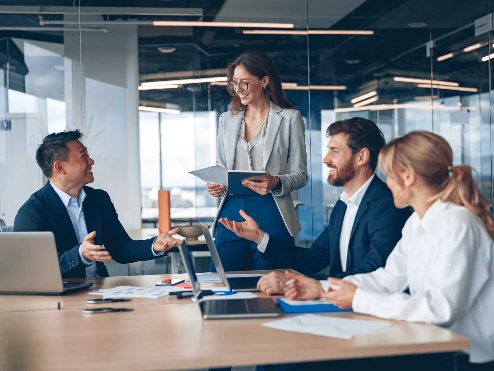 Business meeting in a modern office; professionals discussing ideas around a conference table.