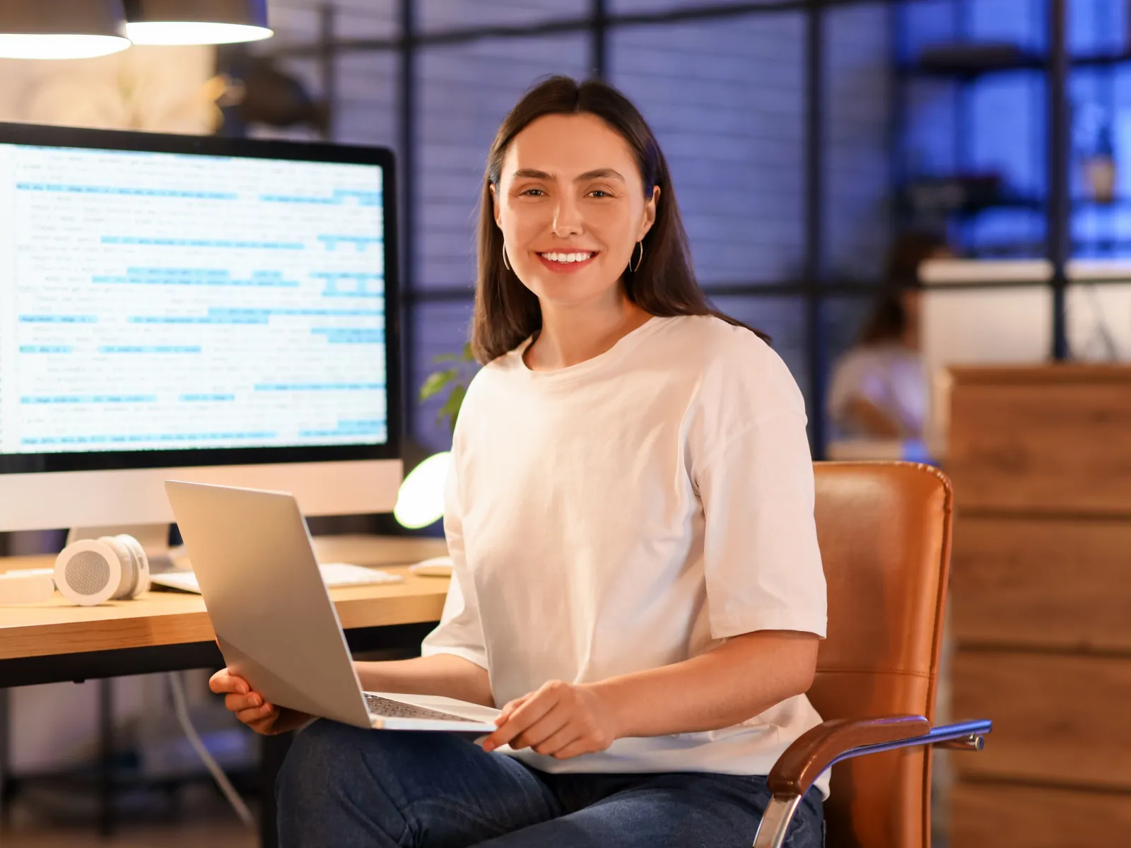 a person sitting at a desk with a laptop