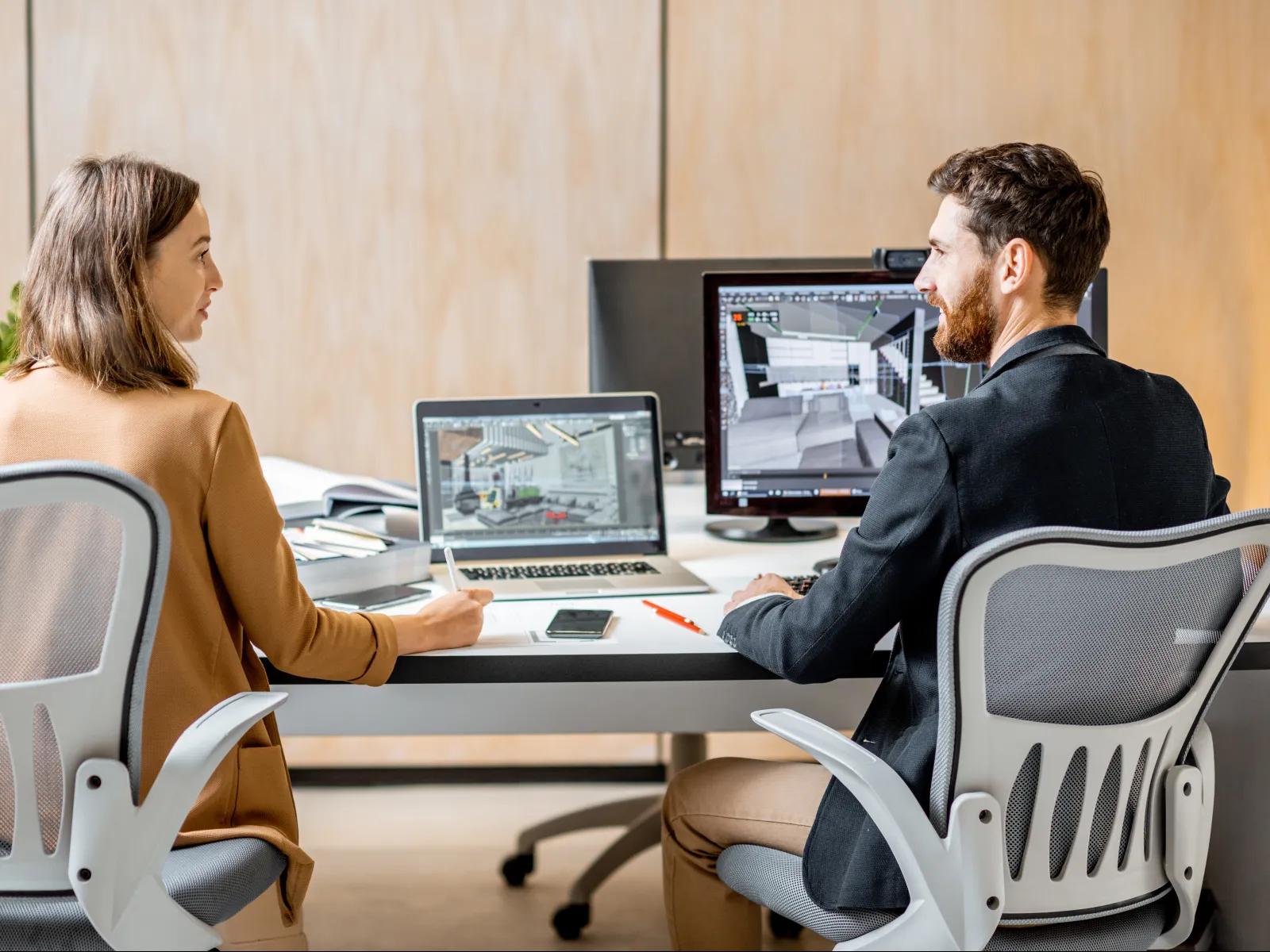 a man and a woman sitting at a table with computers