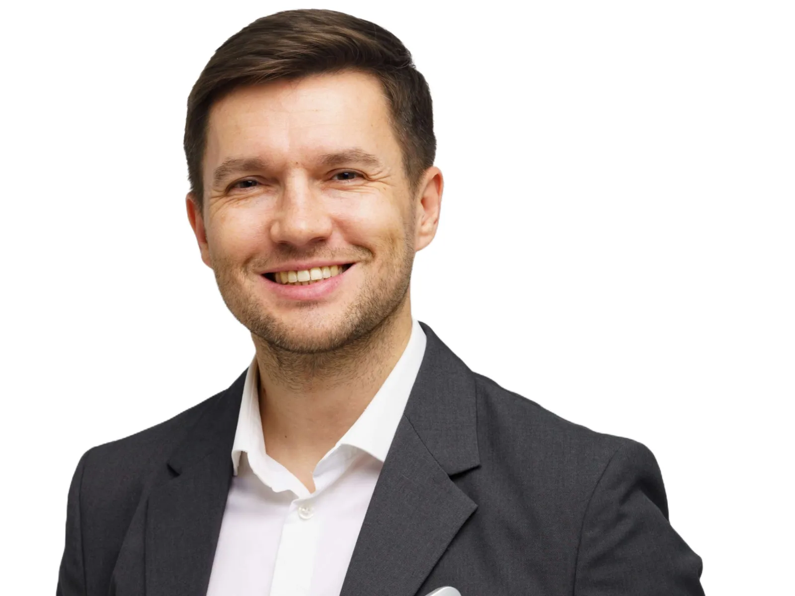 Smiling businessman in dark suit holding closed laptop against white background