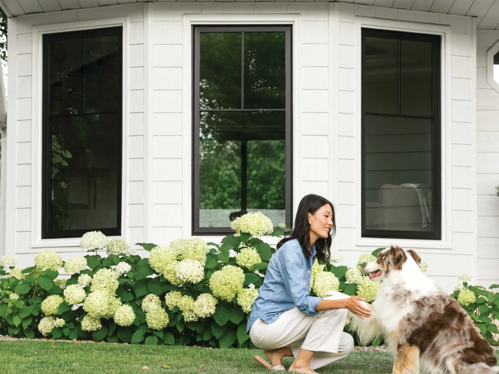 Nashville homeowner petting a dog in front of energy-efficient Black Infinity by Marvin windows