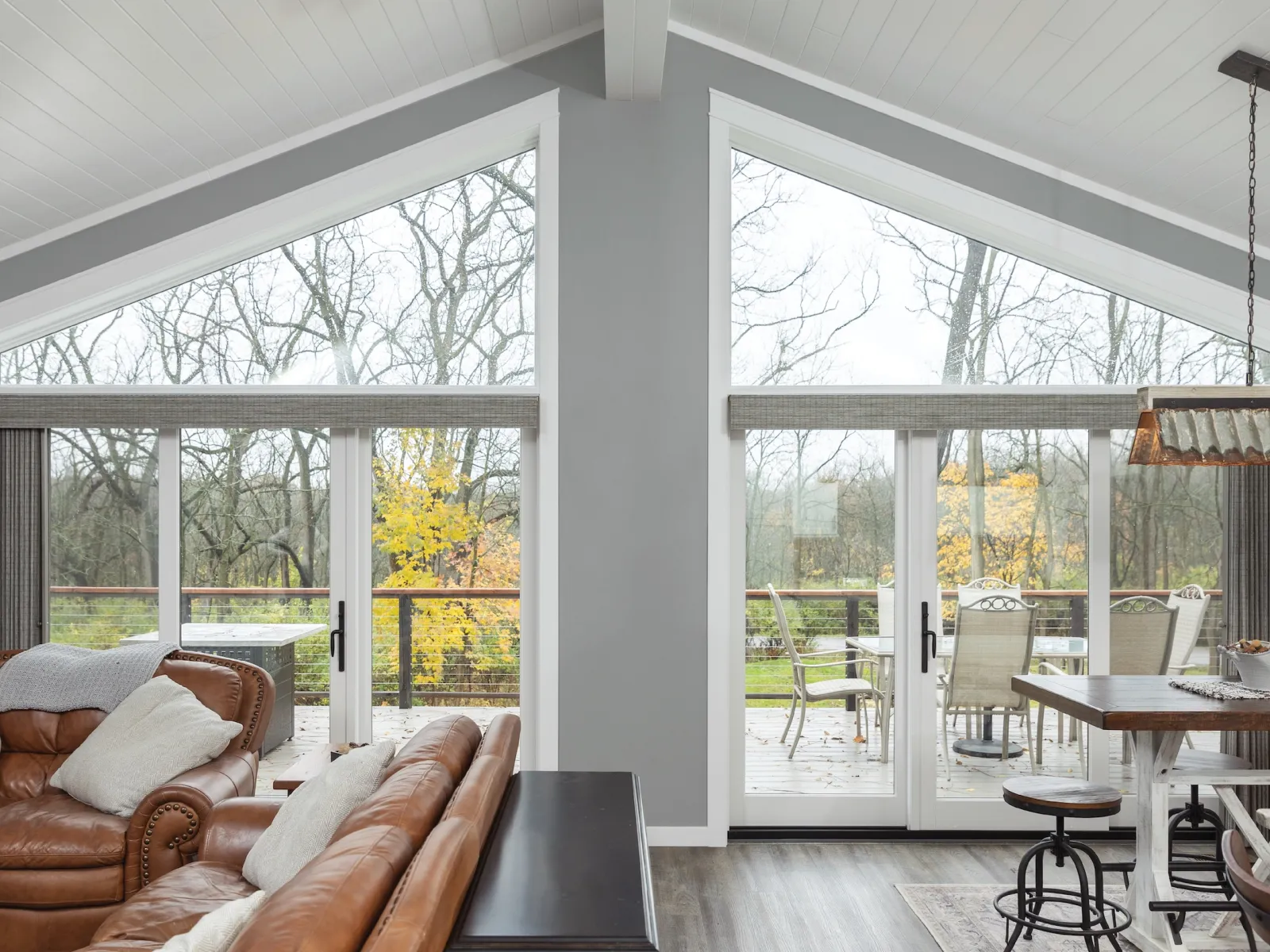 Spacious modern living room with large windows and cozy furniture overlooking a serene outdoor view.