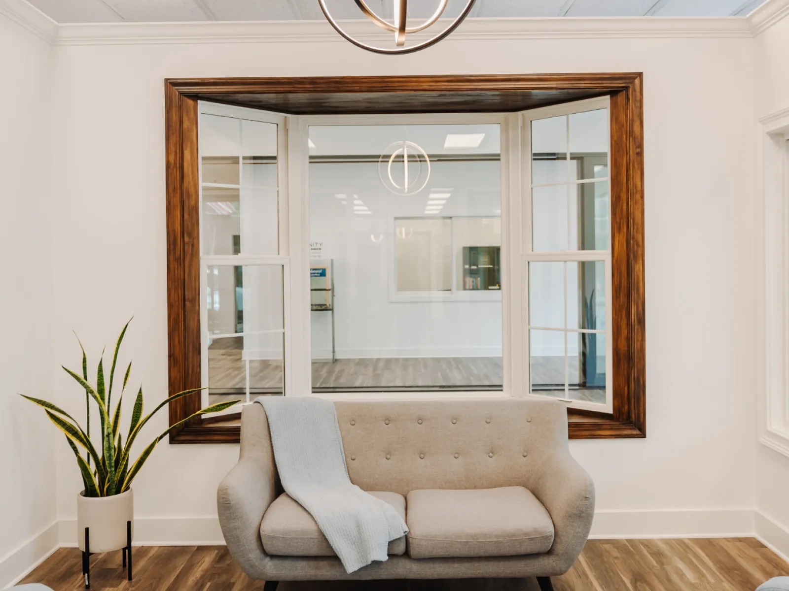 Infinity from Marvin fiberglass bay window with white frame and stained wood trim at North Georgia Replacement Windows' showroom in Alpharetta, GA.