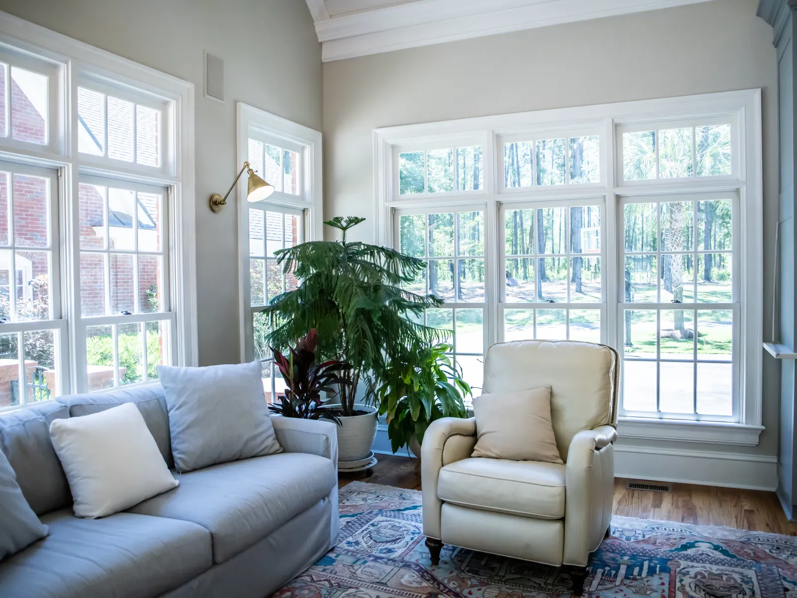 a living room with a couch and a chair and fiberglass replacement windows with sound reducing technology