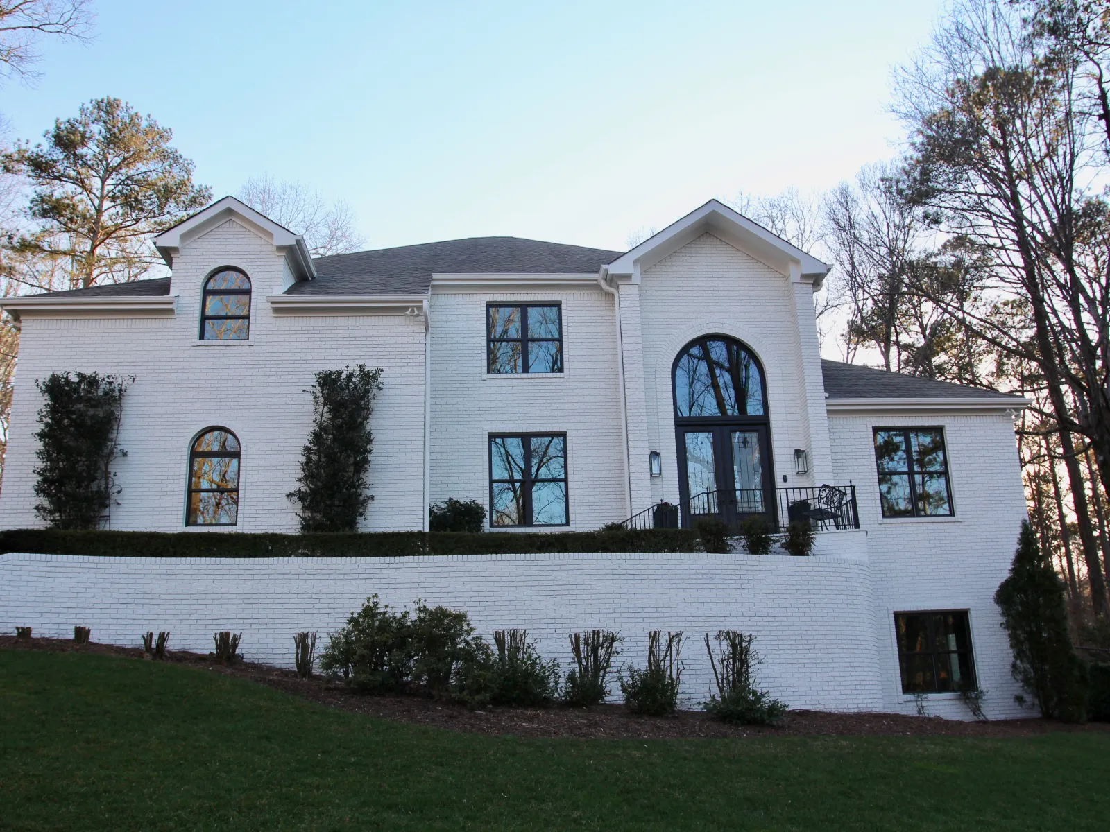 Custom replacement window installation by North Georgia Replacement Windows with round top and double hung windows on a white house.