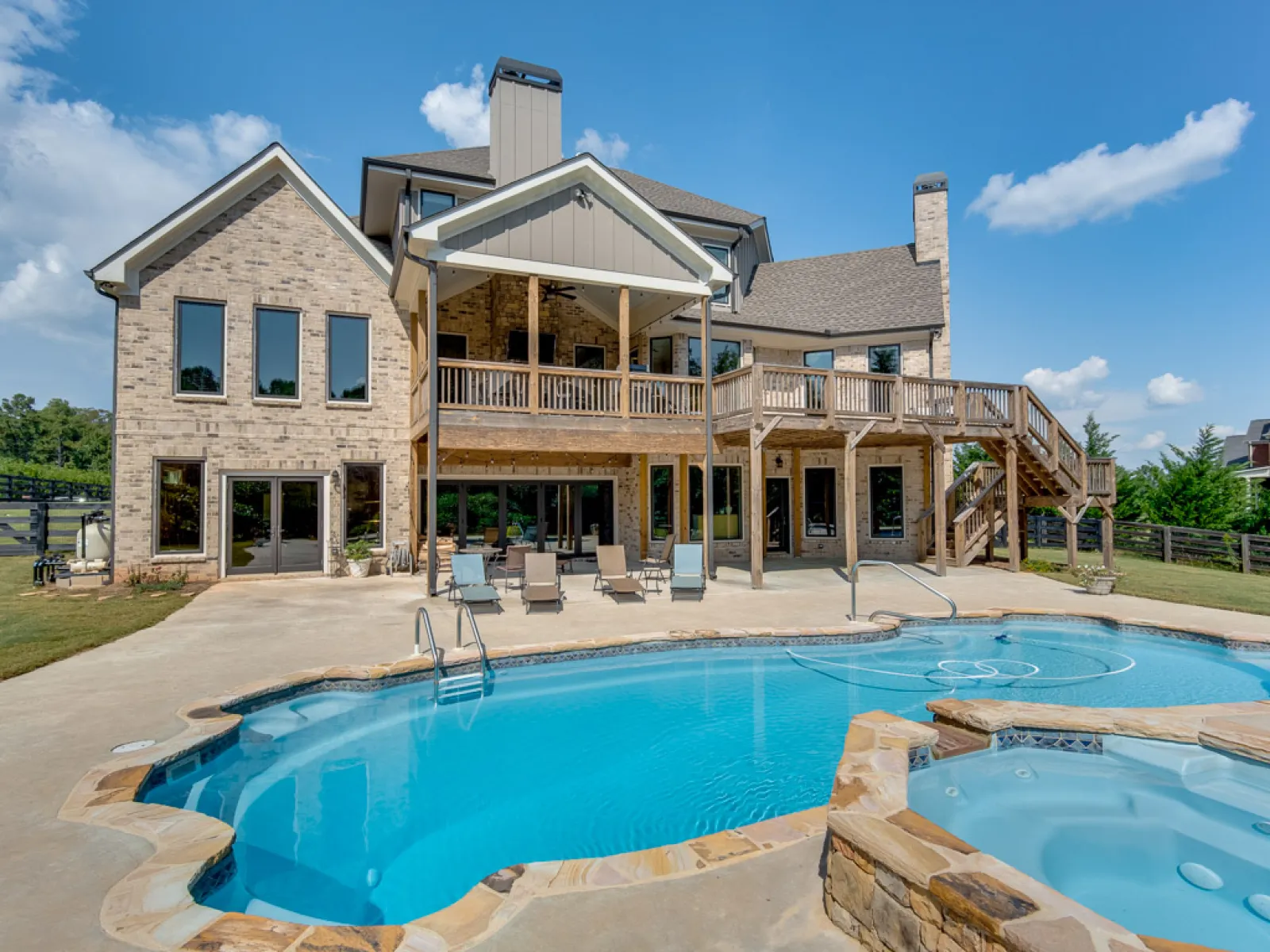 Pool in front of brick house with Infinity from Marvin bi-fold, multi-slide doors and windows