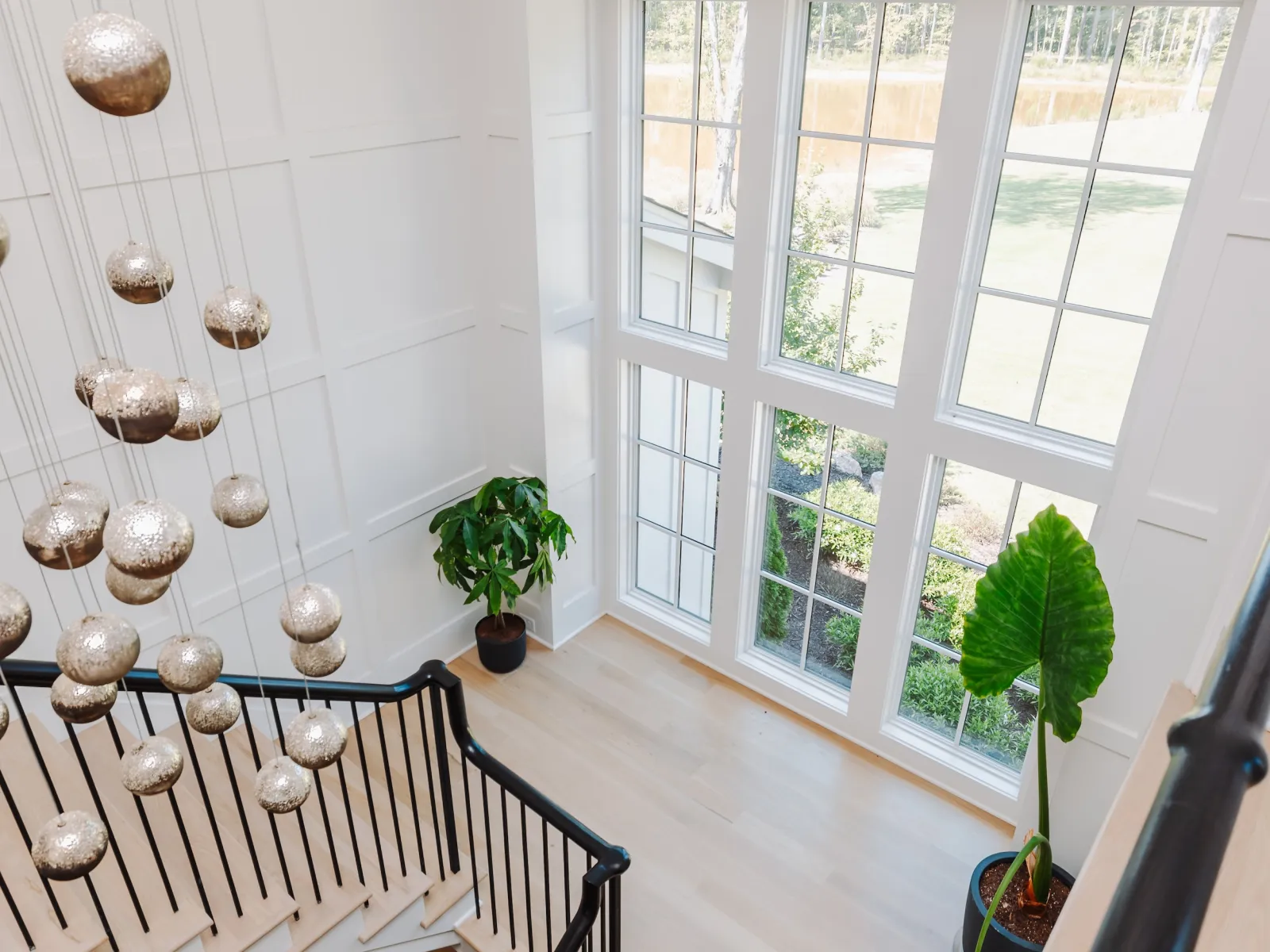 a staircase with a chandelier and a window