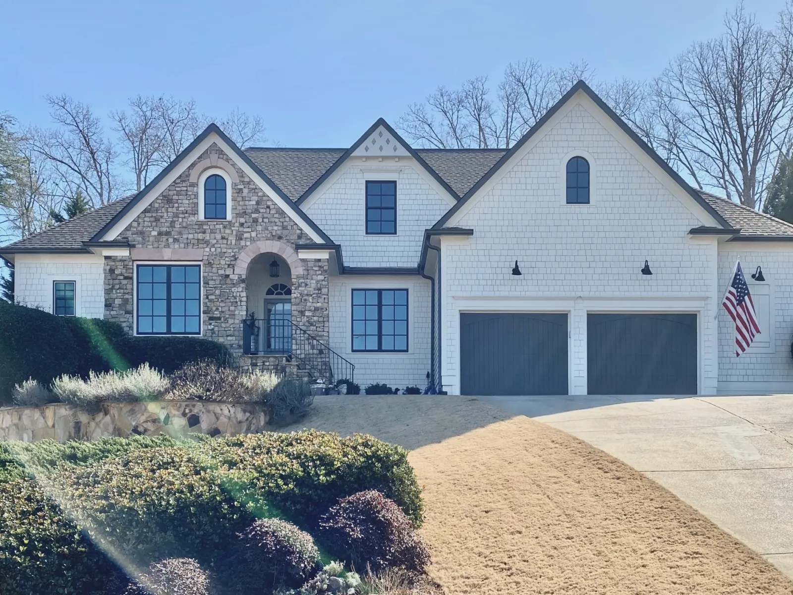 A large stone and brick house with modern black fiberglass windows from Georgia's #1 Infinity Windows Installer