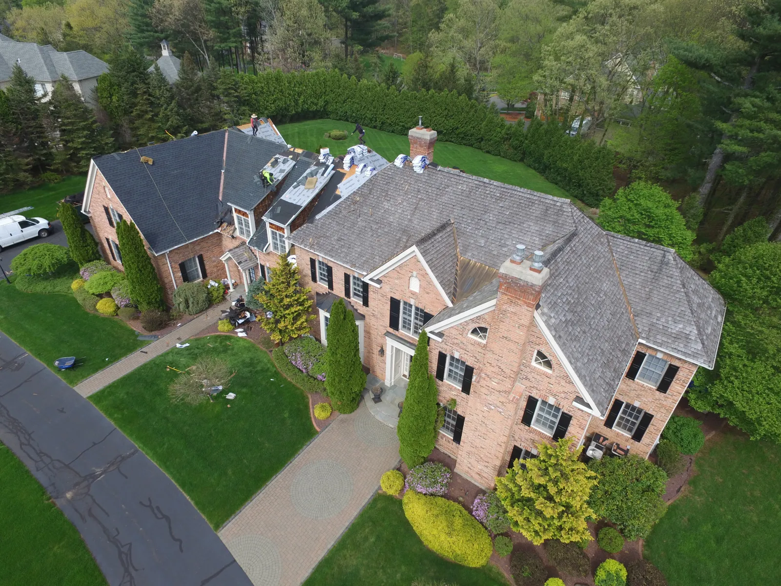 roofers installing a new roof on a large house in connecticut