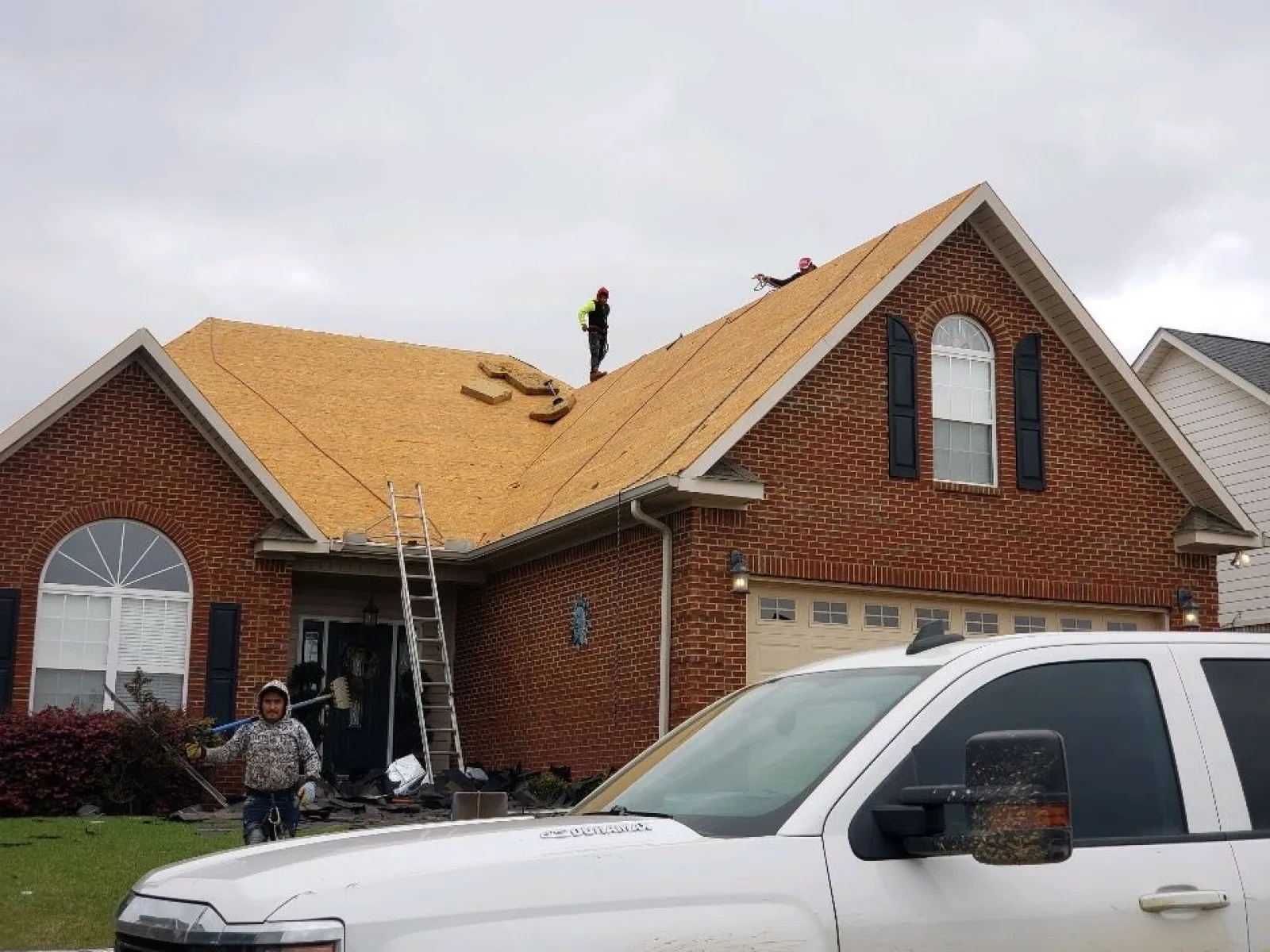a person on a ladder on a roof of a house