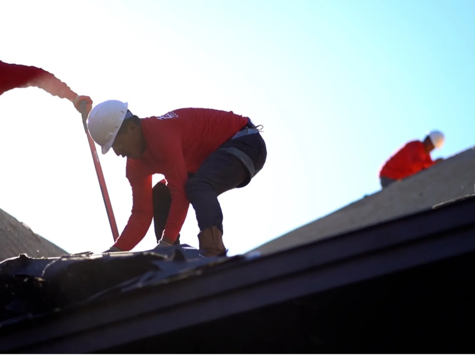 a few men working on a roof