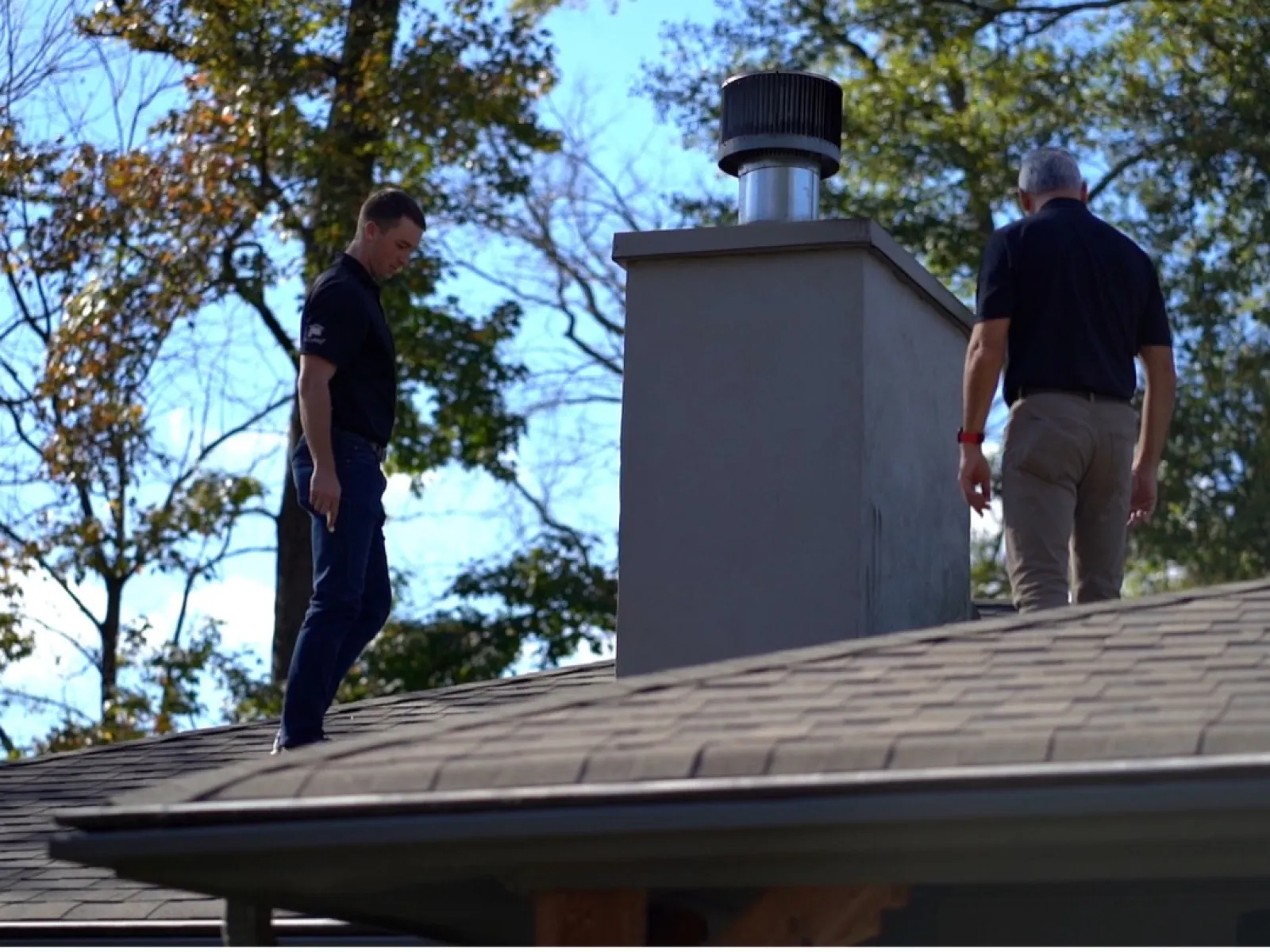 a couple of men standing on a roof