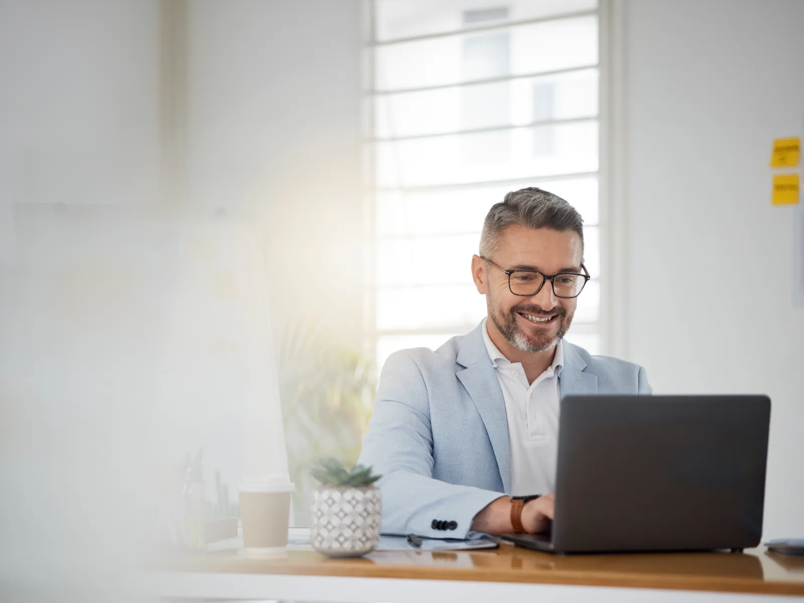 a person sitting at a desk with a laptop