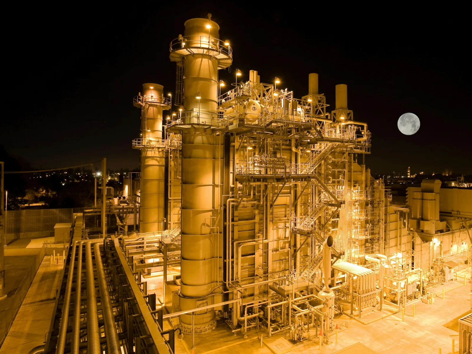 a factory with a moon in the background