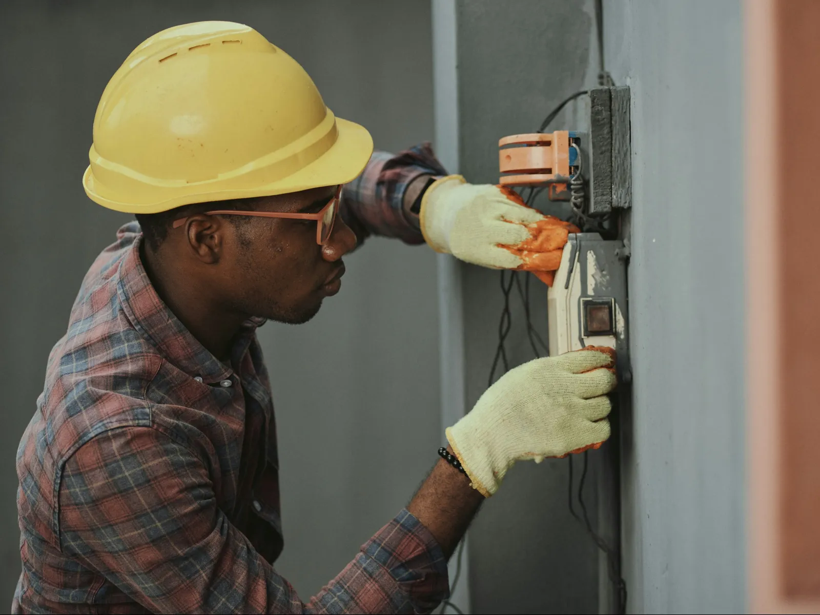 a man wearing a hard hat and holding a drill