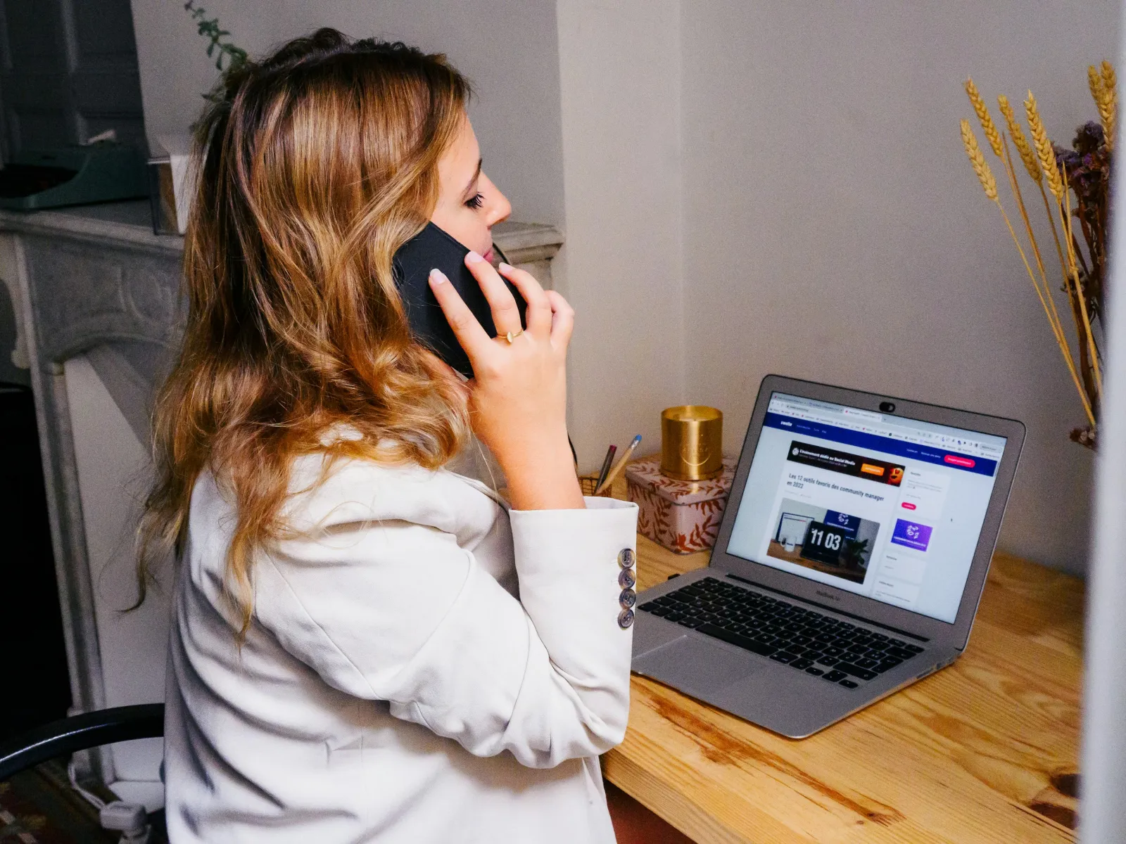 a person sitting at a desk with a laptop and a phone