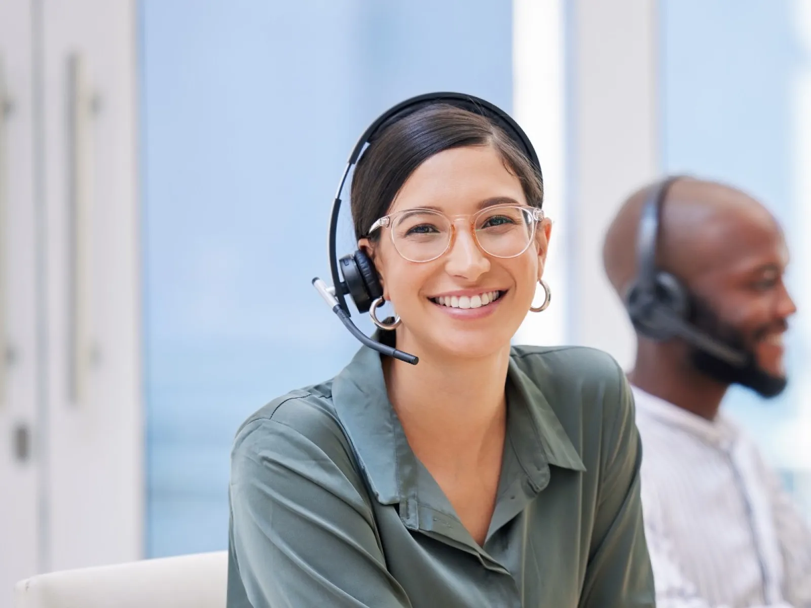 a man and a woman wearing headphones and sitting at a desk