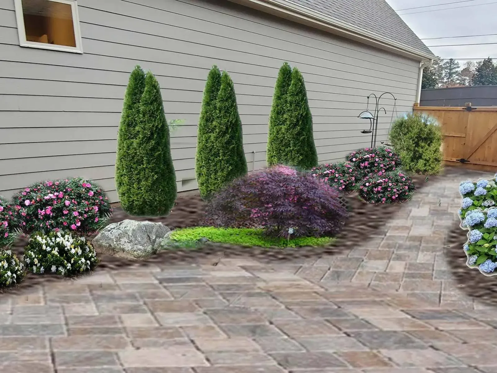 a house with a brick driveway and plants in the front