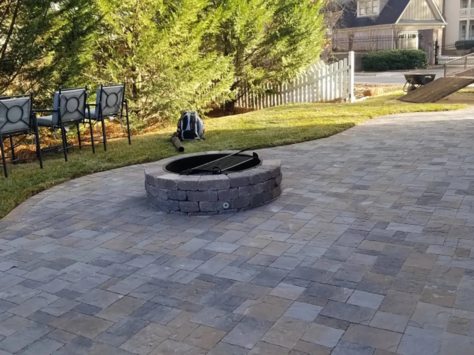 a brick walkway with a stone circle and a stone circle with a black object on it and a