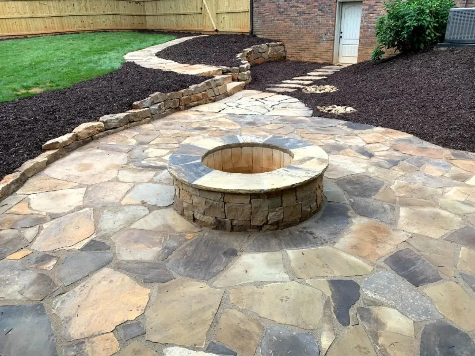 a stone path with a brick wall