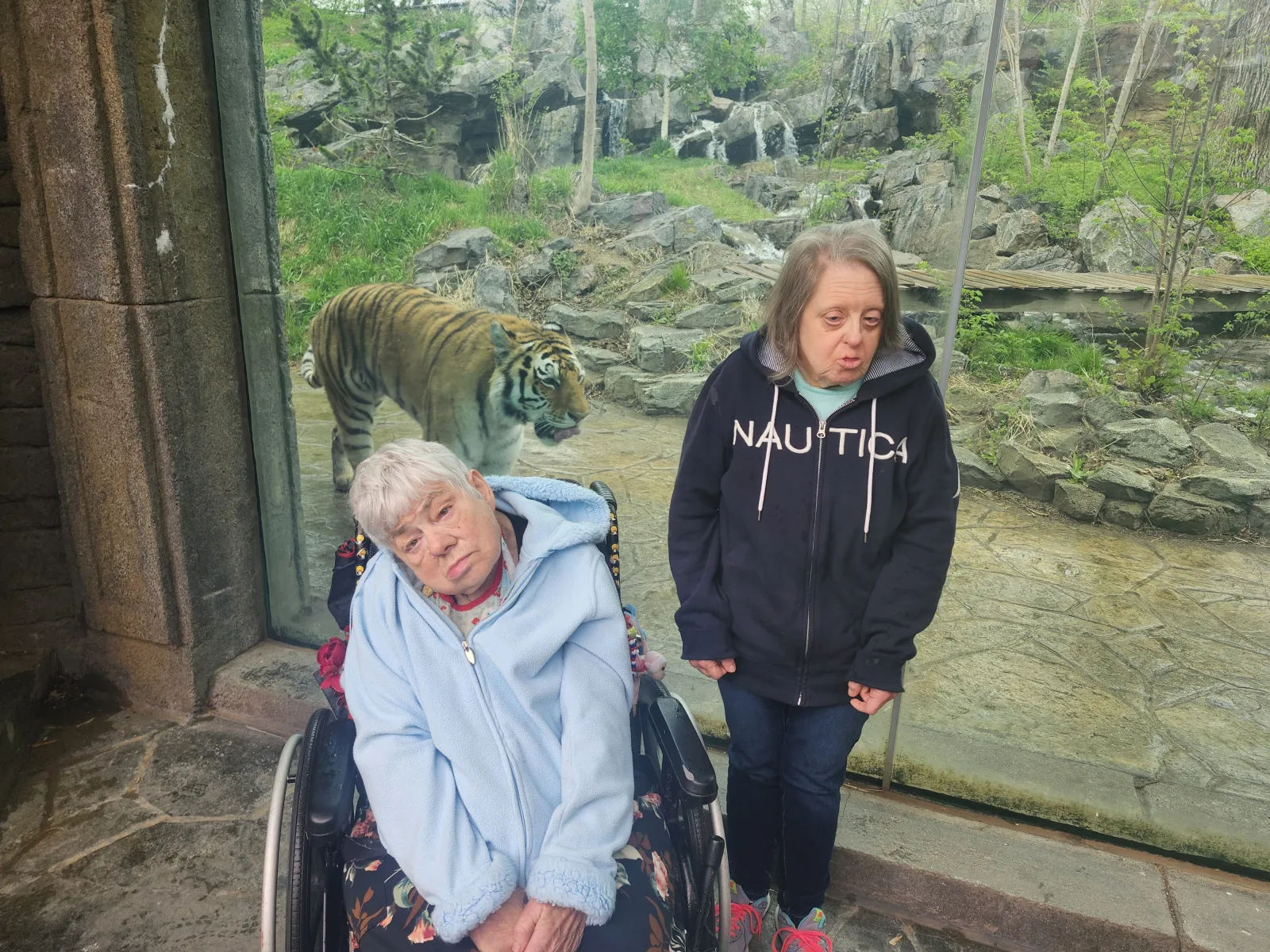 a couple of women posing for a picture with a lion statue in the background