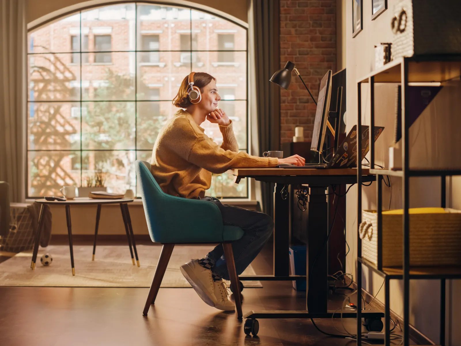 A woman working at a desk in a cozy home office, surrounded by natural light and stylish decor.