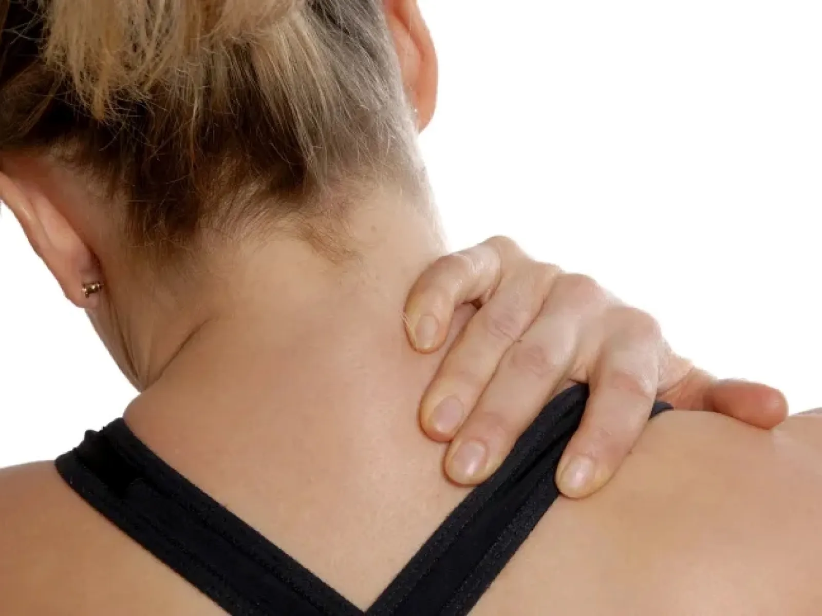 Woman in black tank top holding her neck and shoulder in pain or discomfort against white background.
