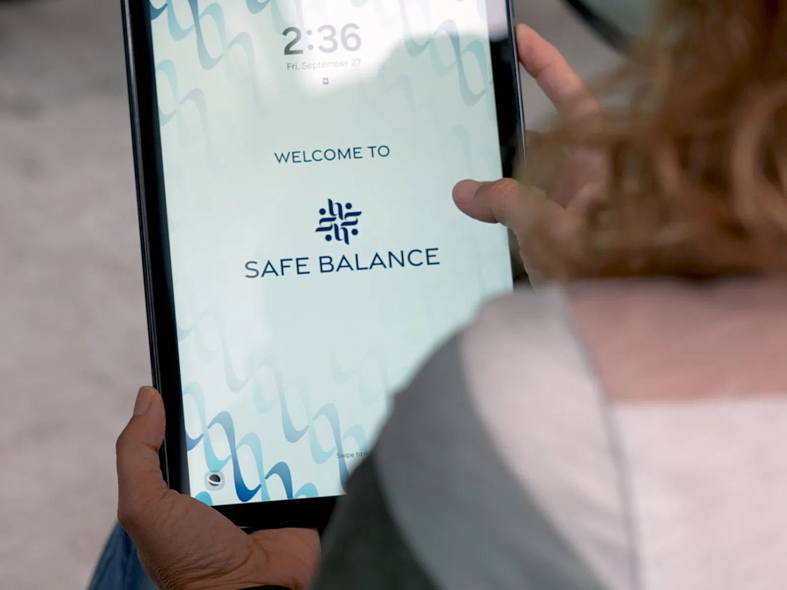 Person holding a tablet displaying the welcome screen of Safe Balance app at 2:36 pm.