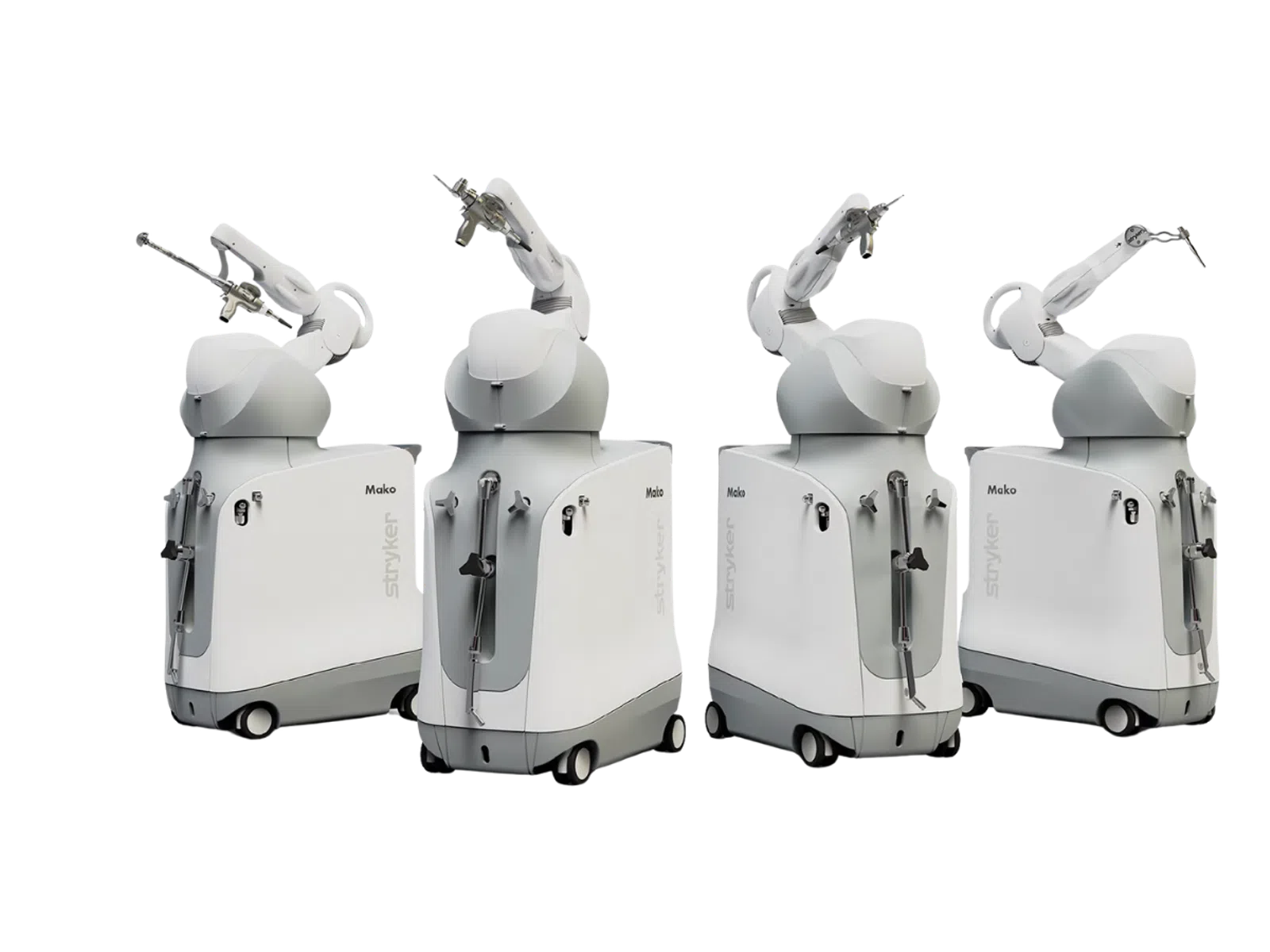 Four white Stryker Mako robotic surgical systems with articulated arms on wheels arranged in a row.