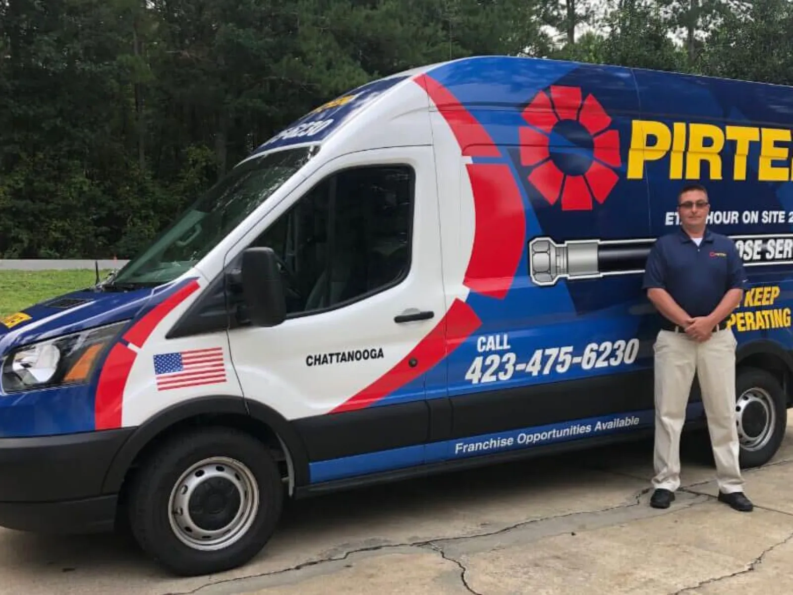 Pirtek service van with company branding and phone number parked outside with a man standing beside it.