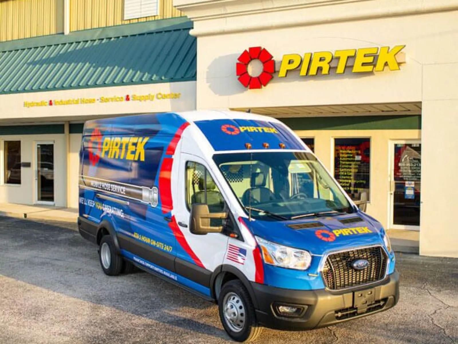 Pirtek service van parked outside a Pirtek hydraulic and industrial hose service center on a sunny day