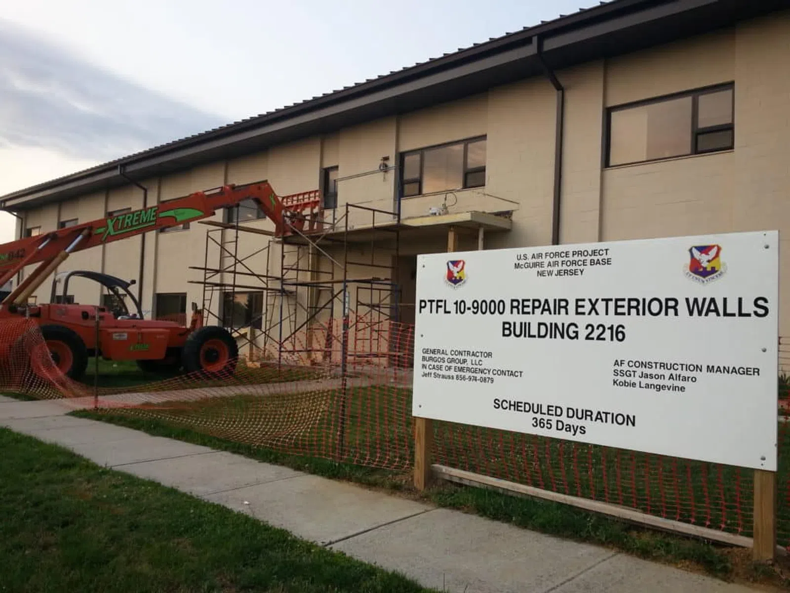 Construction site at McGuire Air Force Base repairing exterior walls of Building 2216 with scaffolding and equipment.