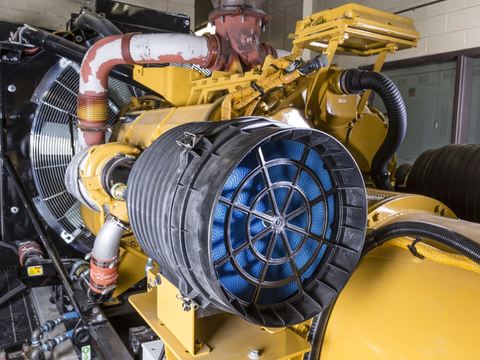 Industrial engine with a prominent air filter, showcasing complex machinery and mechanical components.