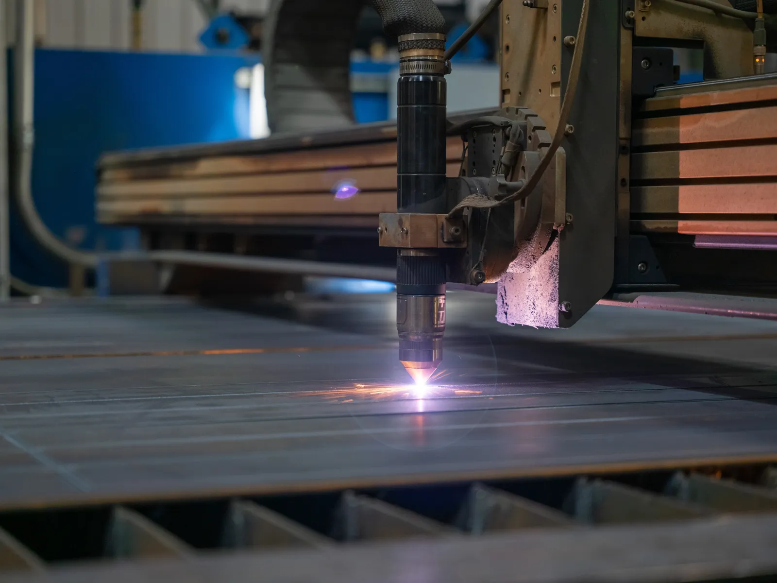 Close-up of a CNC laser cutting machine slicing through metal sheet with bright sparks flying