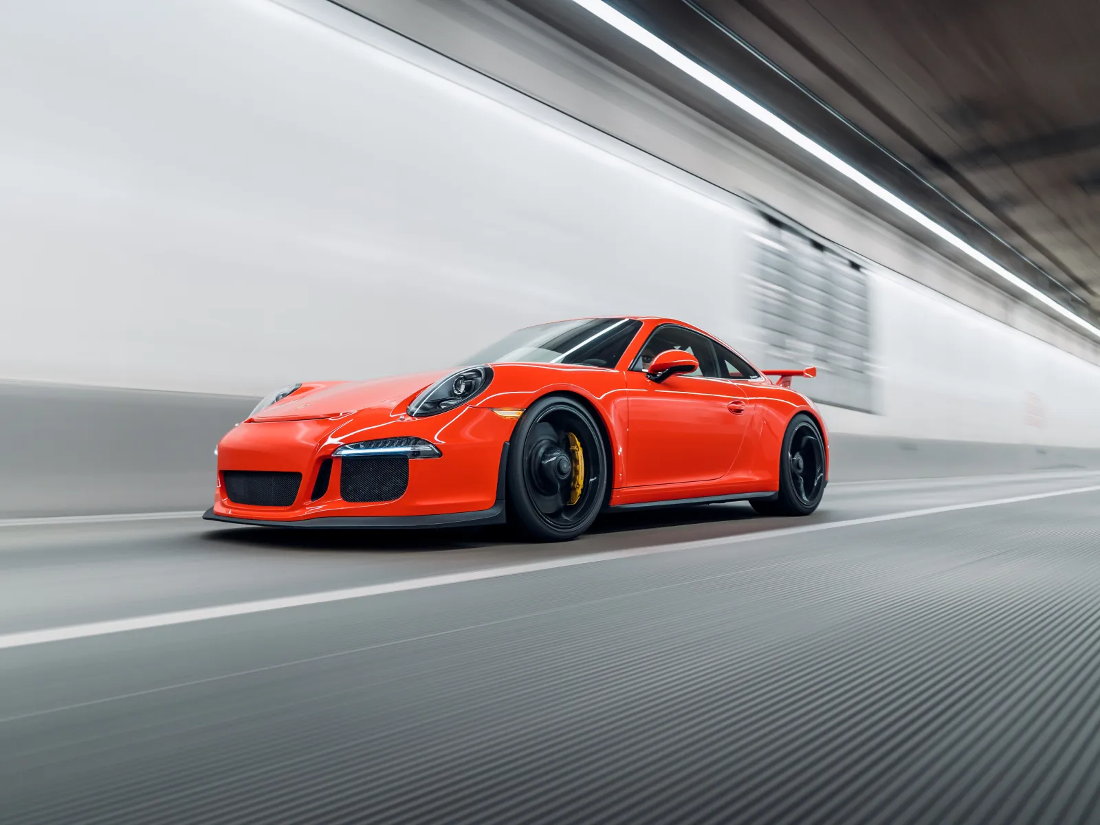 a red sports car driving on a road