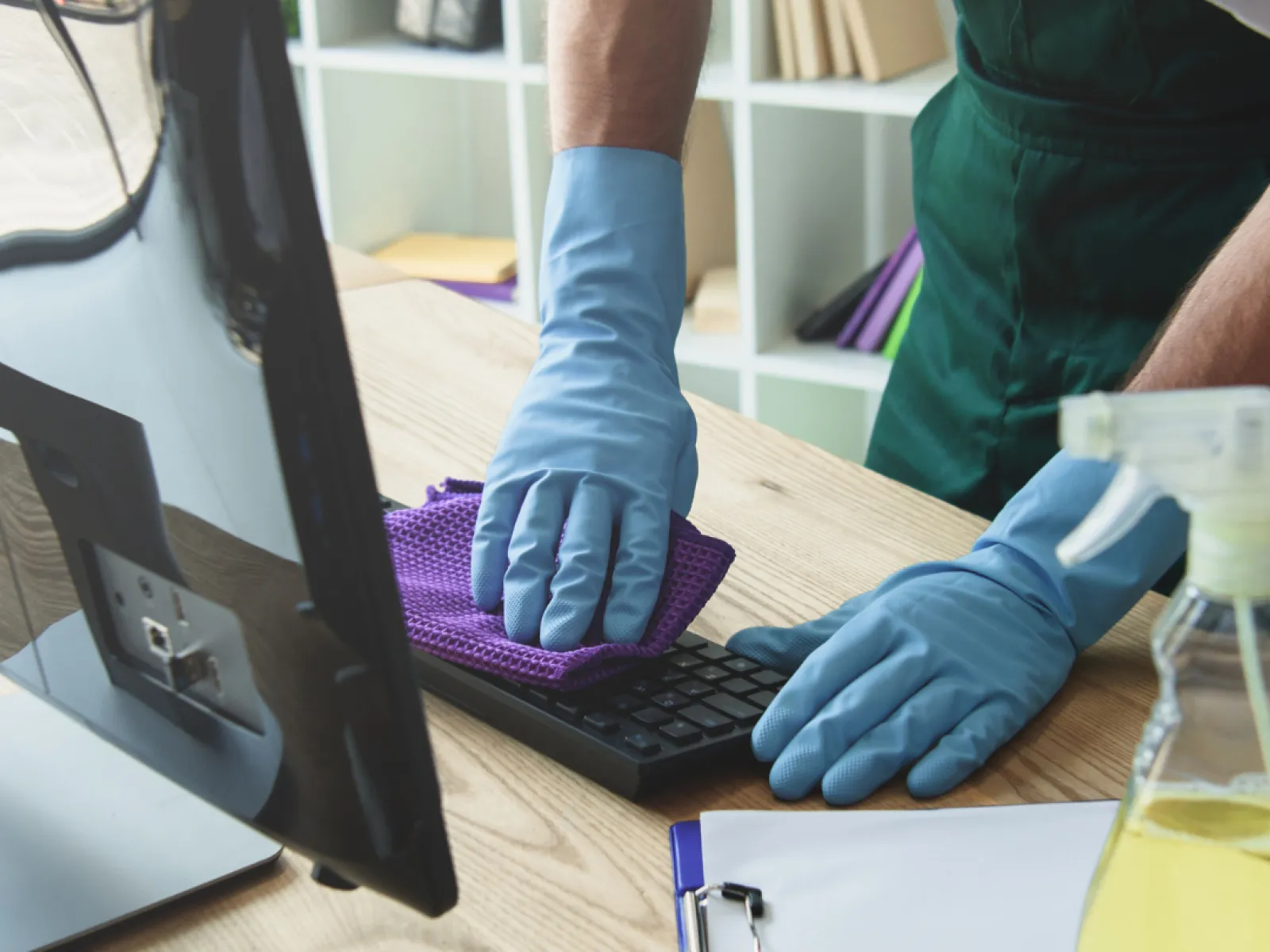a person wearing gloves and a glove using a computer