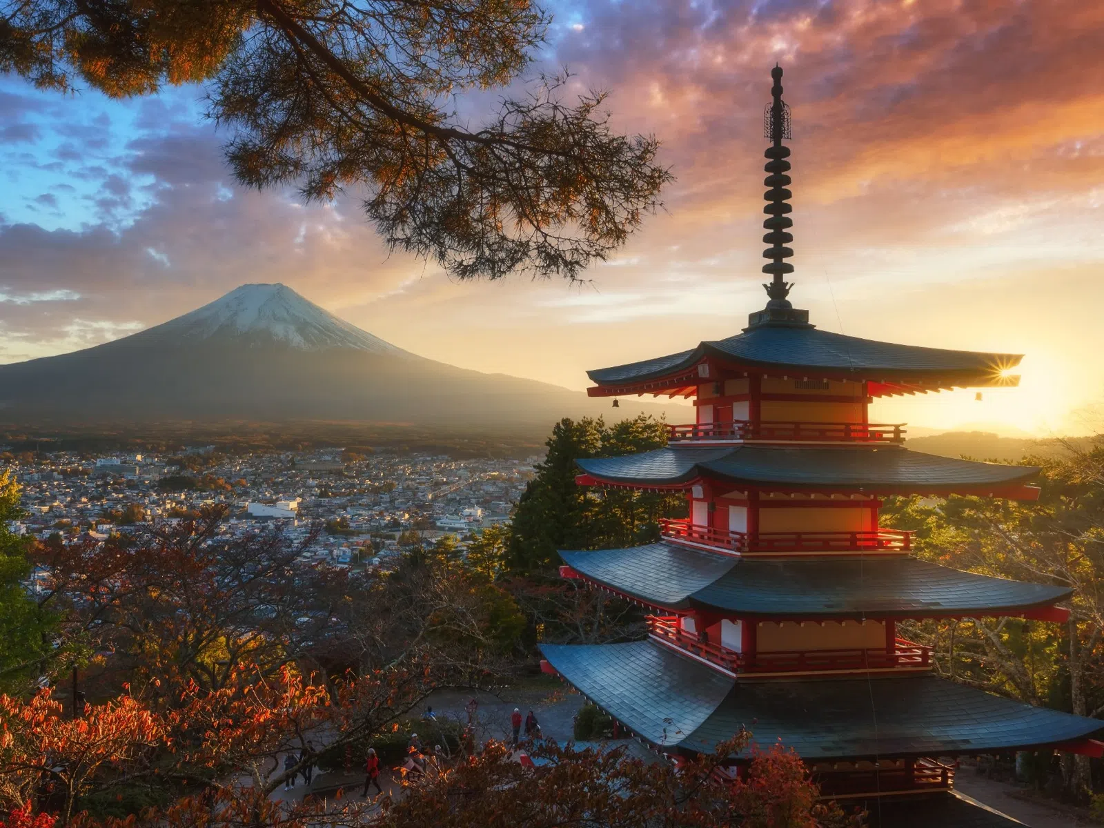 Chureito Pagoda with Mount Fuji in background during vibrant sunset and autumn foliage in Japan.