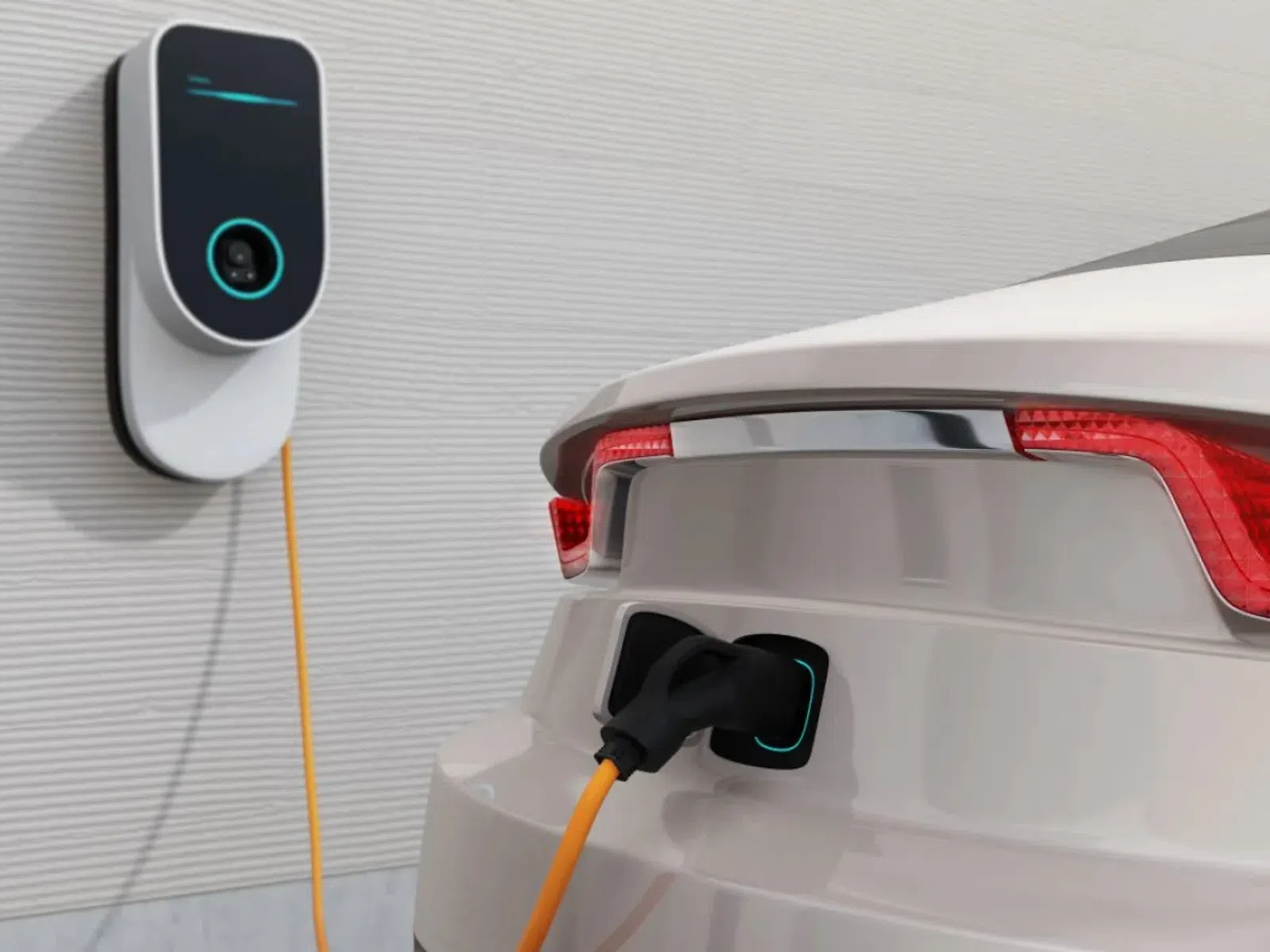 White electric car charging with an orange cable connected to a wall-mounted EV charger in a modern garage